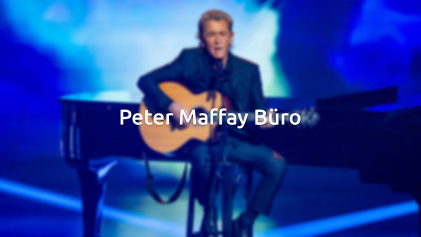 Peter Maffay an der Gitarre vor einem Flügel
